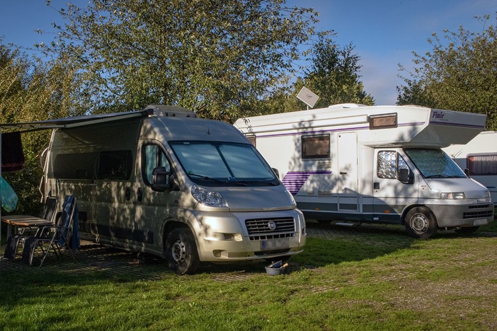 Two motorhome/camper pitches side by side on a corner
