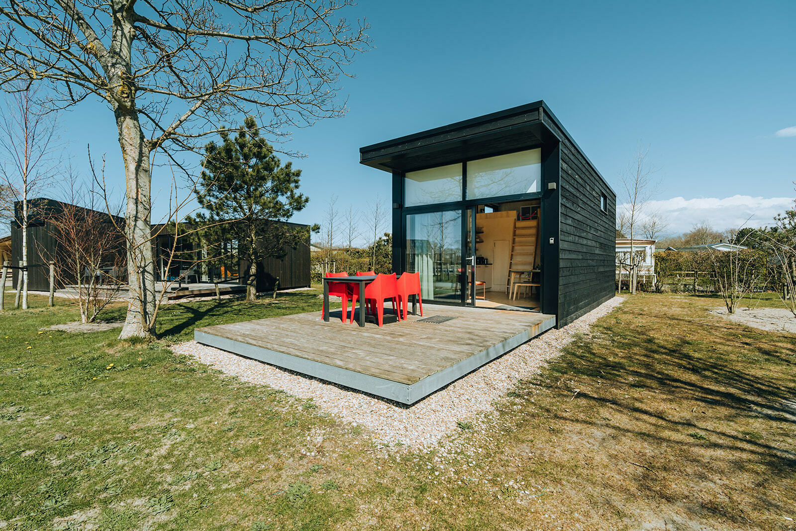 Staal en hout geven karakter aan deze nieuwe vakantiewoning voor vier personen. Met vanaf je eigen, zonnige terras een mooi uitzicht op de zwemvijver!