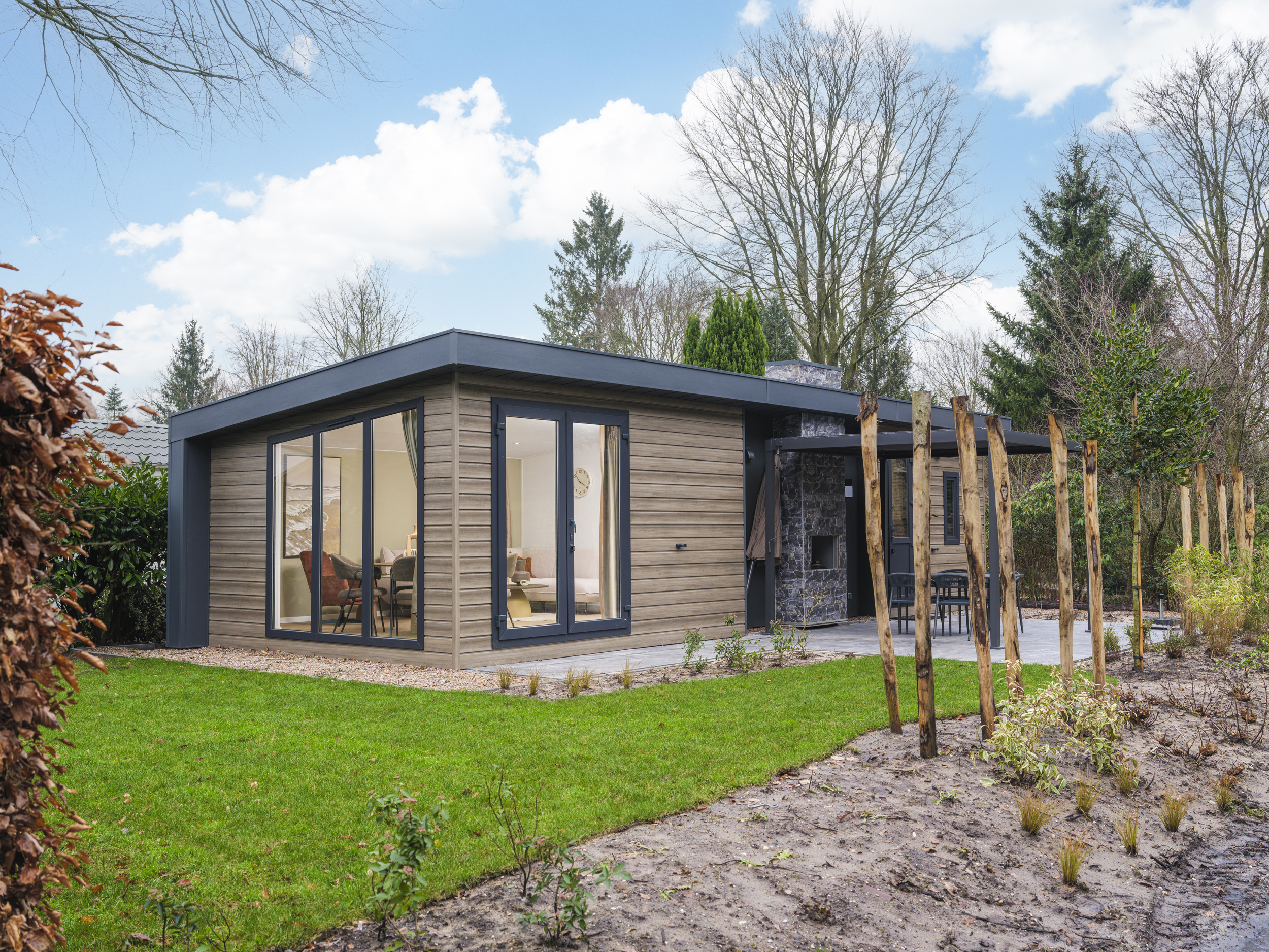 Geniet van een vakantiewoning in de bosrijke natuur van de Veluwe, compleet met moderne voorzieningen en een stijlvolle pergola voor optimaal comfort.