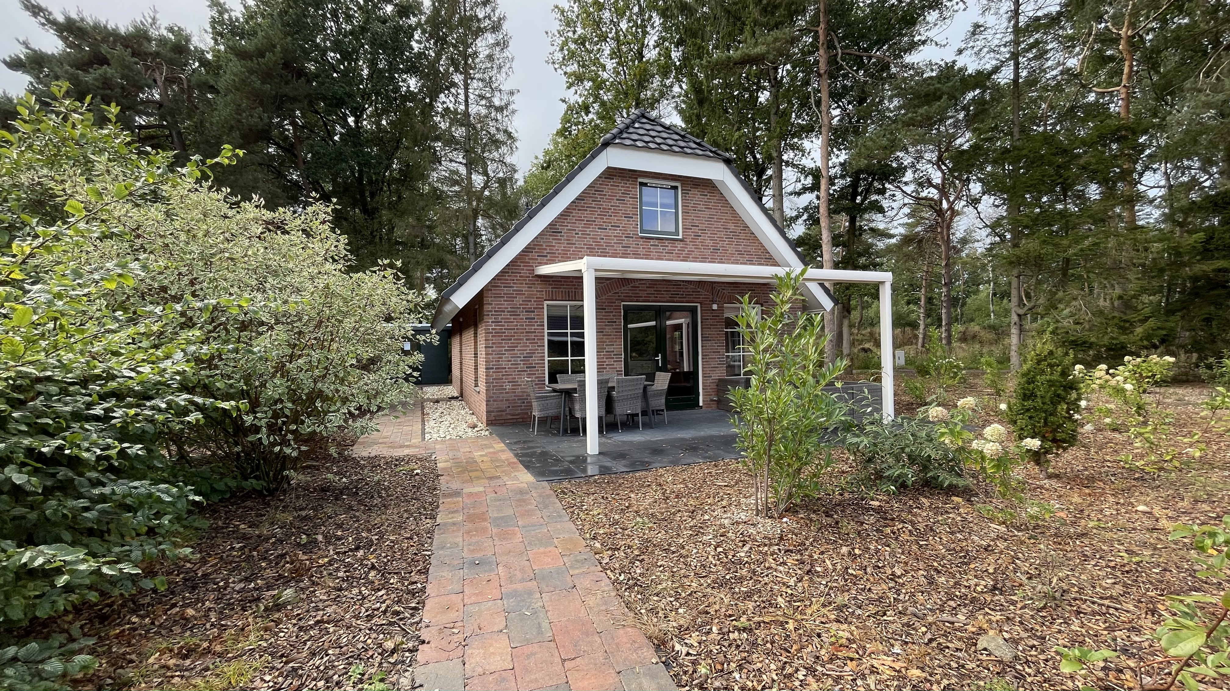 Wellness bungalow met bubbelbad, sauna, sunshower, 3 slaapkamers en overdekt terras met loungeset.